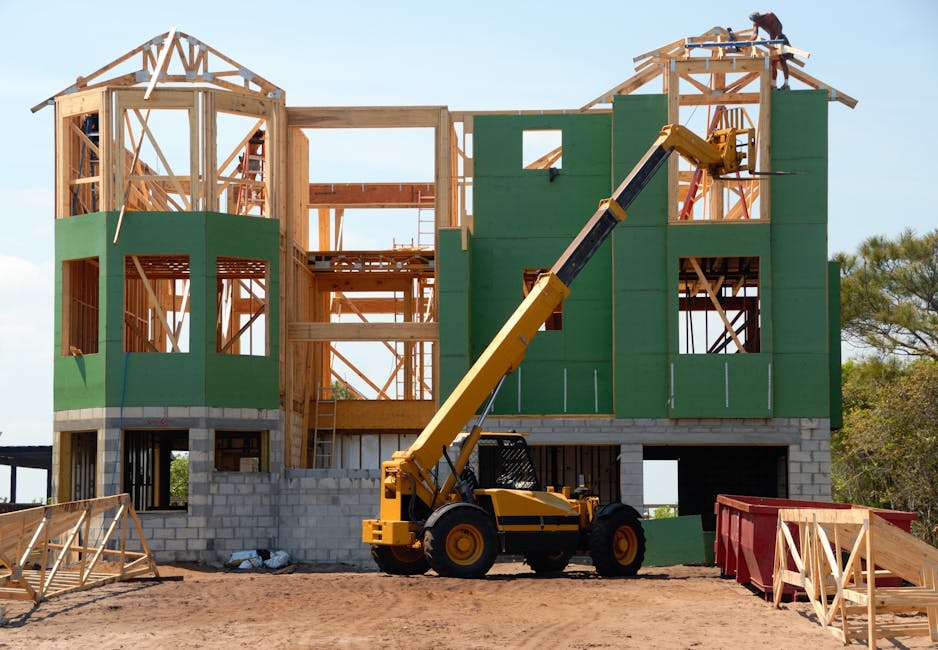 A multi-story wooden house under construction using a crane on a sunny day